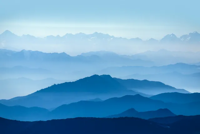 Layers of misty blue mountains under a clear sky
